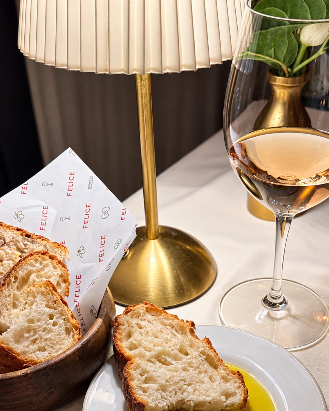 Bread basket and Felice house olive oil beside a glass of rosé