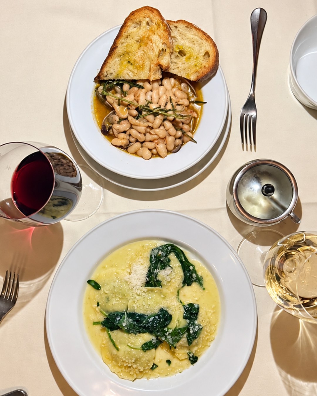 Overhead view of the pasta course with red and white wine