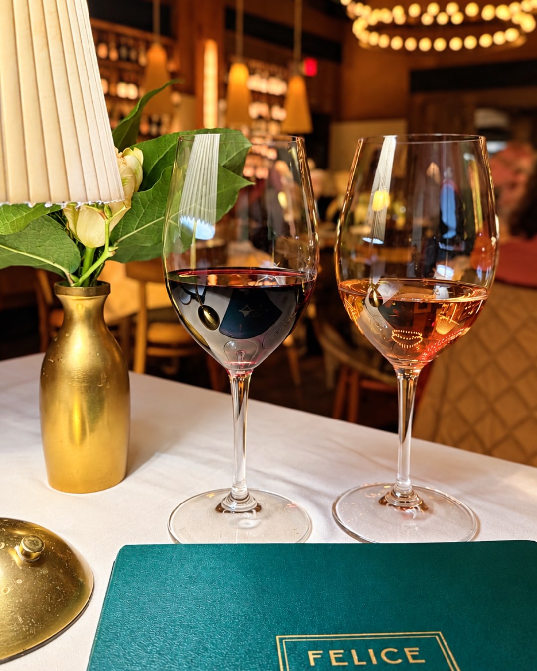 A glass of Cabernet and Felice rosé beside the green Felice menu
