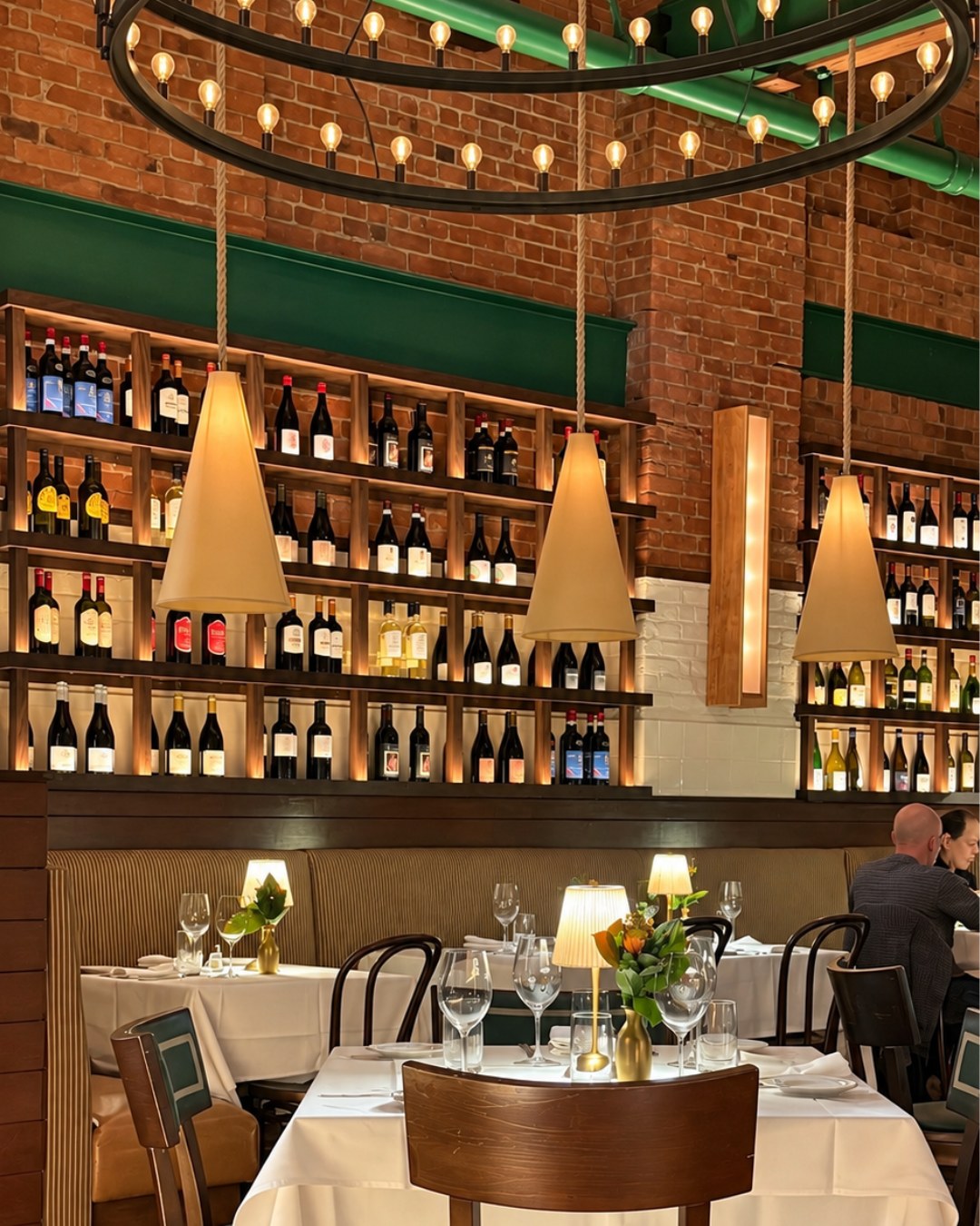 Wine wall, ring chandelier and cone pendants over the banquettes at Felice Port Chester