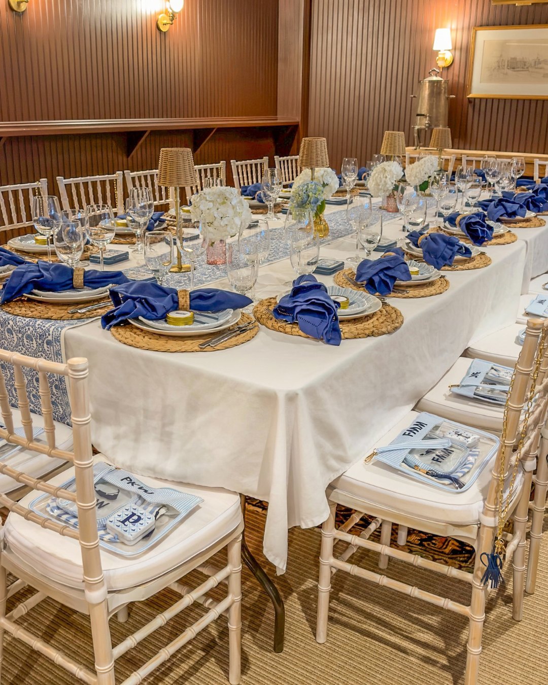 A long table set in blue and white with hydrangeas and woven chargers in Ahab's Room at Nantucket Inn
