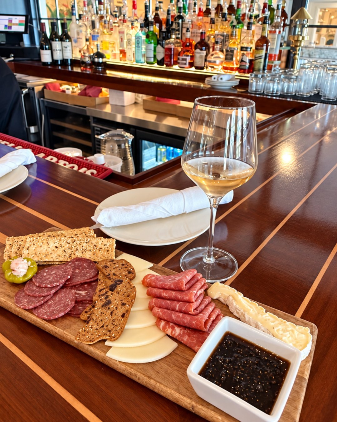 Charcuterie and white wine on the wood bar at Nantucket Inn
