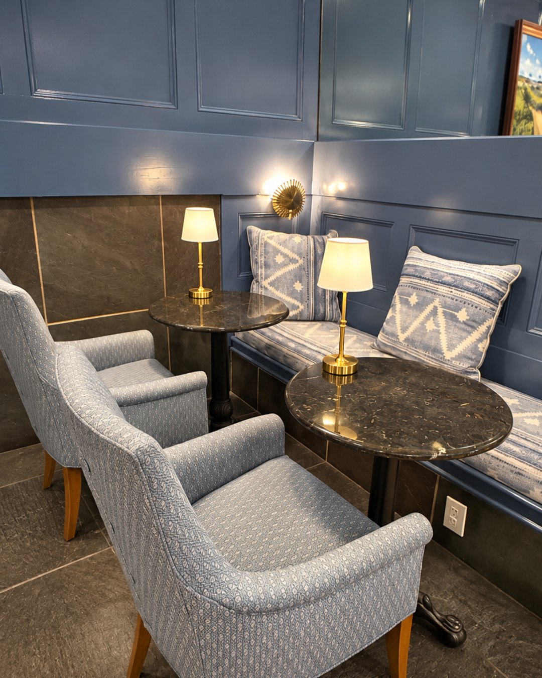 Blue paneled lounge with upholstered chairs and brass lamps at Nantucket Inn
