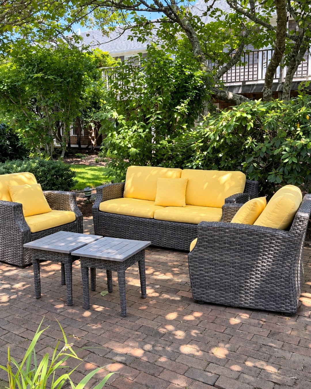 A shady garden patio with yellow cushioned seating at Nantucket Inn
