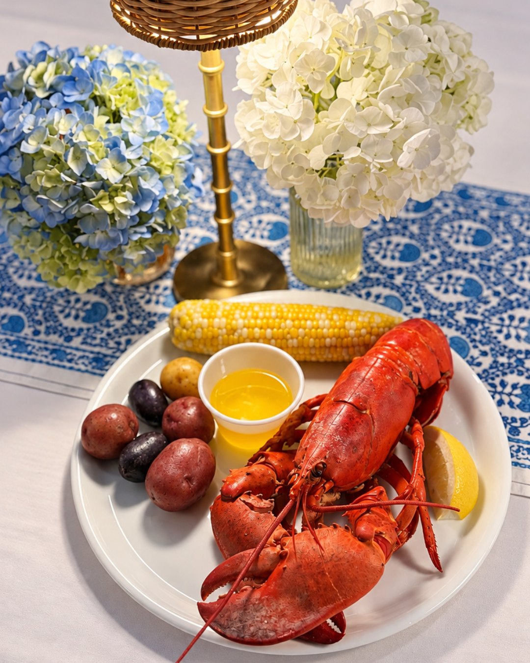 A lobster dinner plate with corn, potatoes and drawn butter at Nantucket Inn