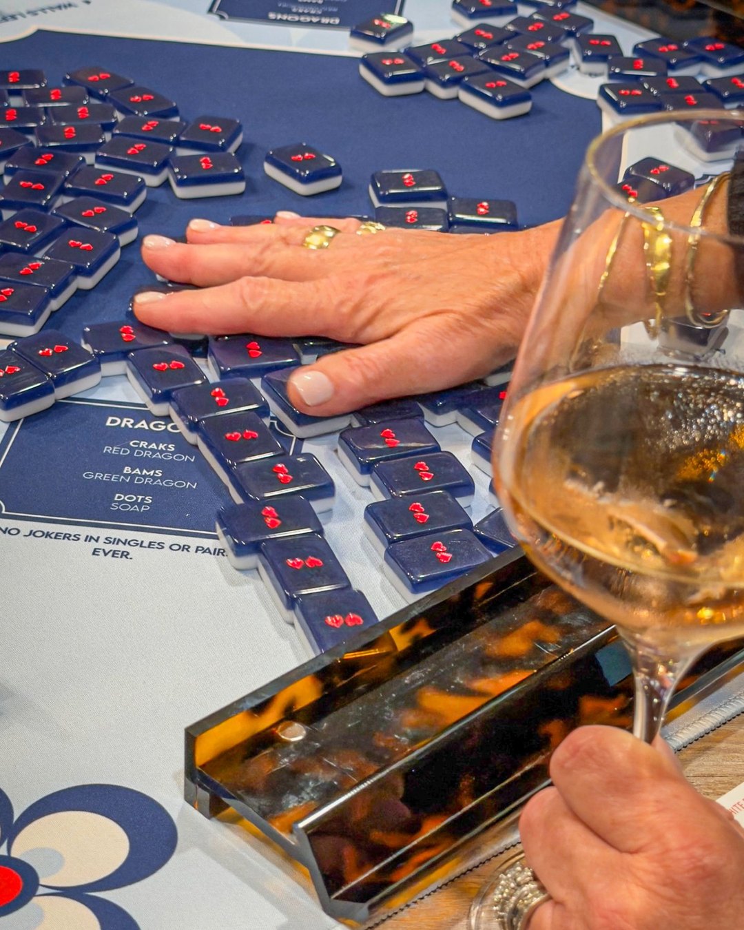 Mahjong tiles and a glass of rosé during a THREADS game night