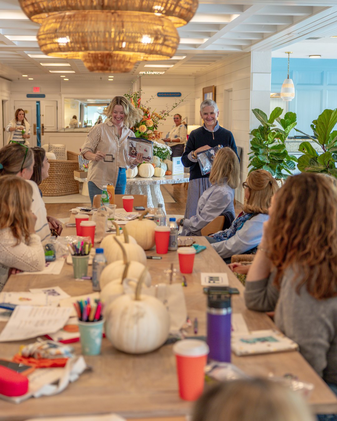 A THREADS needlepoint workshop around a long table under a woven chandelier at Nantucket Inn